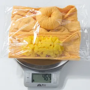 Gros plan d'un lot de bandeaux orange pour bébé pesant 46,4 g sur une balance précise