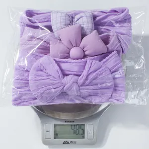 Set de trois bandeaux violets pour bébé sur une balance affichant 48,5 g