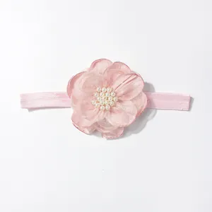 Detailopname van roze baby haarband met gelaagde tule bloemen en witte parels