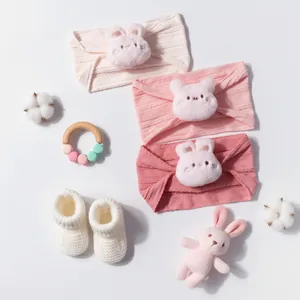 Détails de trois bandeaux tricotés pour bébé en dégradé de rose avec oreilles peluches