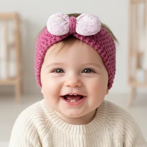 Detail of rose pink knitted baby headband featuring a floral embroidered bow accessory