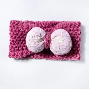 Close-up of knit baby headband in rose red with floral embroidered light pink bow