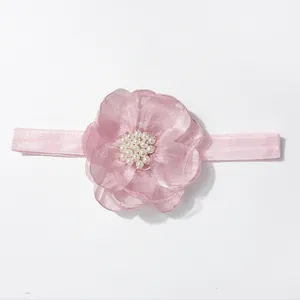 Detail van baby-hoofdband met roze organza bloem en witte imitatieparels decoratie