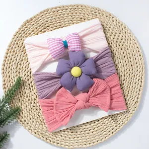 Lot de trois bandeaux pour bébé avec nœud rose et fleur violette sur carte de présentation
