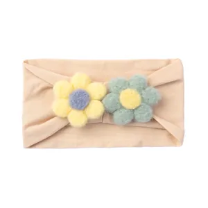 Detail of plush handmade flowers on a soft nylon elastic baby headband in beige