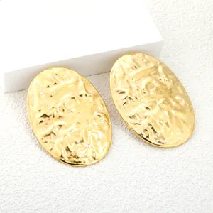 Minimalist gold hammered metal shield earrings with high shine textured finish