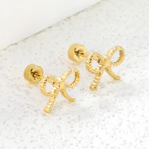 Elegant gold bow earrings with twisted texture and secure screw back on white stone