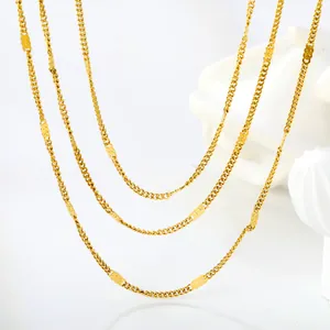 Three-layer gold stainless steel layered necklace with oval pendants on a white background