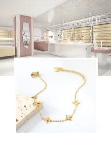 Detail of 18k gold plated stainless steel bracelet with small airplane charms and lobster clasp