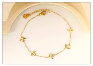 Detail of 18k gold plated stainless steel bracelet with five small airplane charms