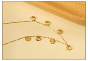 Detailaufnahme goldener Muschelanhänger an einer feinen Kette mit maritimen Strukturen