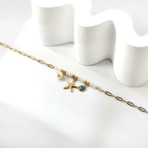 Bracelet de cheville or 18k avec perles blanches, étoile de mer et breloque œil bleu