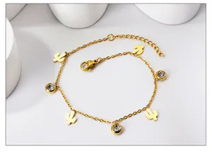 Detail view of gold 18K stainless steel anklet with cactus charms and zircon crystals