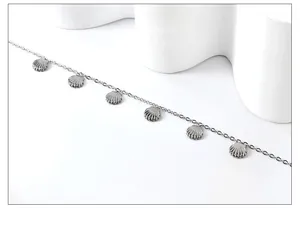 Detailed view of silver stainless steel anklet featuring delicate seashell charms