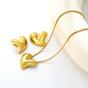 Vue détaillée de l'ensemble collier et boucles d'oreilles cœur 3D doré poli