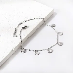 Silver stainless steel shell anklet on a white stone tile for beach jewelry