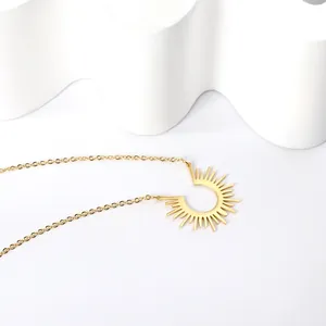 Dettaglio della collana con ciondolo a sole dorato lucido su decoro bianco