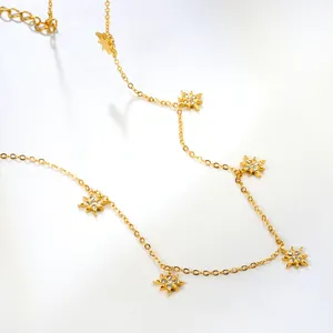 Close-up of gold chain necklace featuring star pendants with sparkling crystal inlay