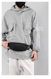 Detail of waterproof black crossbody bag with red ribbon tag and quick-release buckle