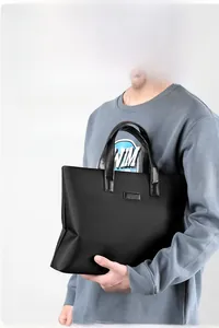 Detailed side view of a minimalist black business laptop bag with reinforced handles