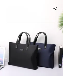 Detail of waterproof nylon business briefcases in black and navy blue on an office desk