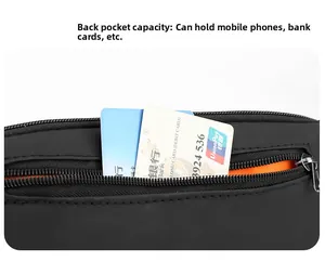 Detail of waterproof crossbody bag back pocket with orange lining holding a phone and cards