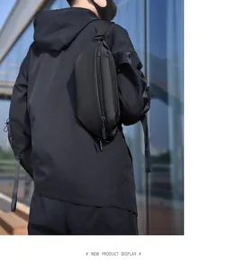 Outdoor male model wearing a sleek matte black tactical leg bag against a modern glass wall