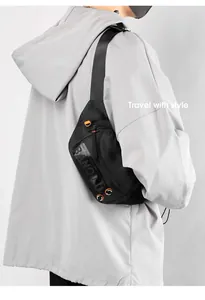 Detail of waterproof black crossbody bag showing textured mesh and orange D-ring buckle