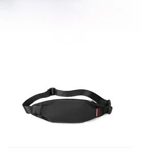 Front view of black waterproof nylon crossbody chest bag with adjustable strap and red tag
