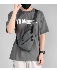 Close-up of gray waterproof chest bag with adjustable strap on model wearing casual t-shirt