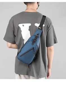 Detail view of water-resistant navy blue sling bag with side USB charging port for men