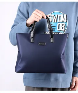 Close-up of navy blue laptop bag with black leather handles and waterproof nylon fabric