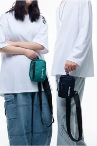 Detail of trendy nylon crossbody bags in green and navy showing texture and zippers