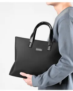 Detail view of the black business tote bag showing its matte texture and leather handles