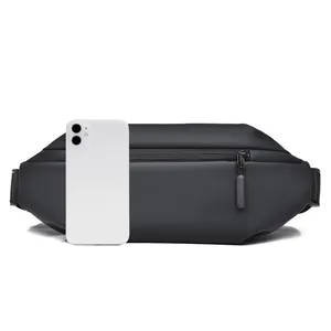 Detailed comparison of waterproof black waist bag next to a smartphone for size reference