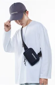 Detail of dark blue nylon crossbody bag with white BANQILU logo and black shoulder strap