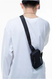 Detail of navy nylon crossbody bag showing the adjustable shoulder strap and zippers