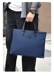 Close-up of man holding a dark blue business briefcase with durable handles