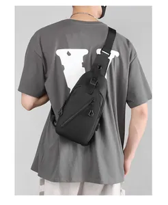 Rear view of a stylish black waterproof crossbody bag with USB port on a male model