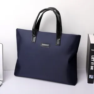 Navy blue nylon business tote bag with black faux leather handles for office commute