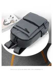 Dettaglio di uno zaino grigio impermeabile con tasche multiple con cerniera su un tavolo