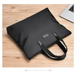 Top view of a professional black laptop briefcase on a modern light wood desk setup