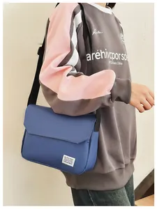 Blue canvas messenger bag with flap closure and adjustable strap shown on model
