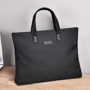 Classic black business briefcase for men featuring leather handles on a wooden table