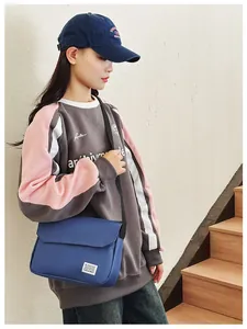 Blue canvas messenger bag with adjustable strap shown in a casual lifestyle setting