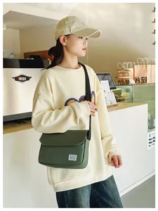 Close-up of a dark green canvas messenger bag with an adjustable strap and flap cover
