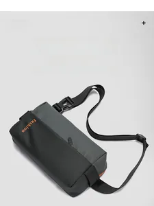 Detail showing grey and black waterproof fabric textures with orange fashion text on bag