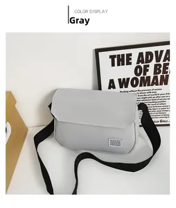 Detailed view of a gray minimalist messenger bag with branded label and nylon strap