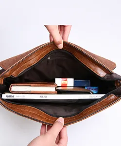 Internal view of brown leather briefcase showing zipper pocket and organized storage space