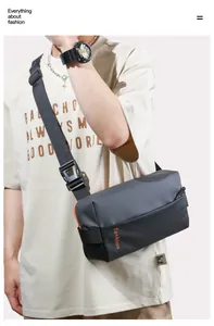 Detail of grey crossbody bag with orange zipper and fashion logo on casual nylon strap